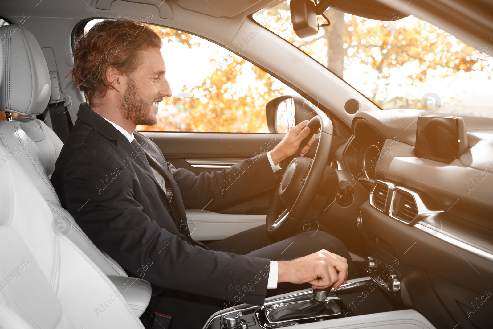 Photo of Young handsome man in driver's seat of modern car