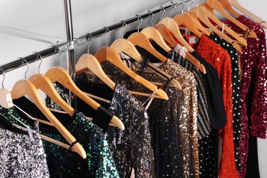 Photo of Collection of different beautiful women's party dresses on hangers in showroom, above view. Stylish trendy clothes for high school prom