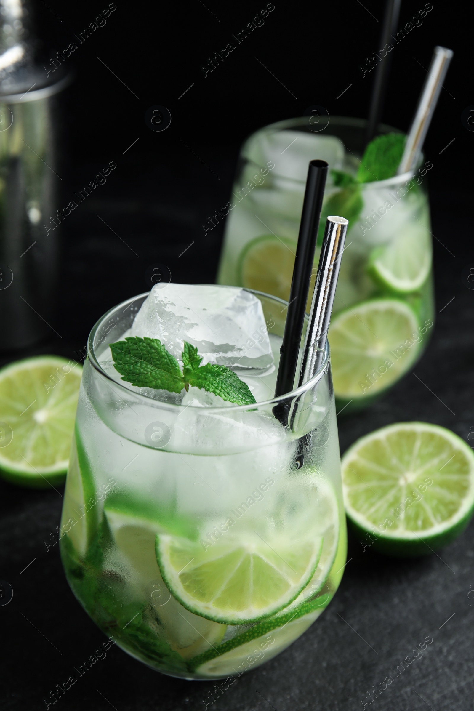 Photo of Delicious mojito and ingredients on black table