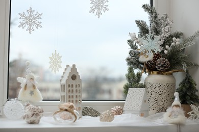 Photo of Many beautiful Christmas decorations on window sill indoors