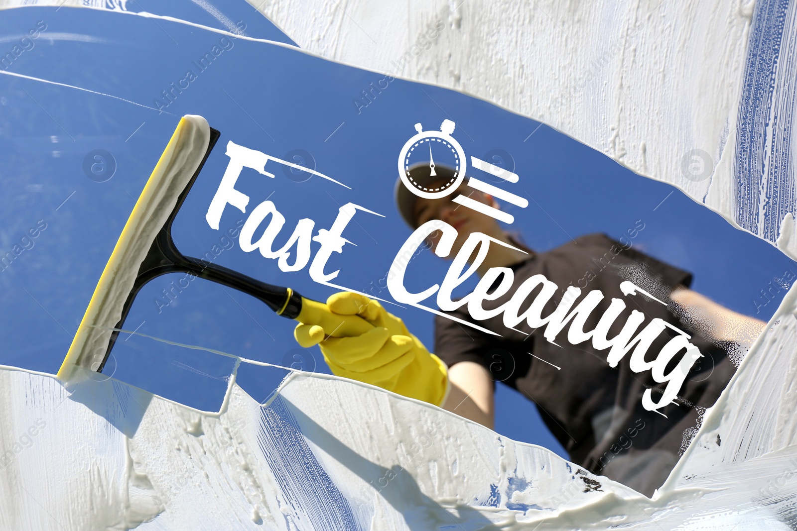 Image of Fast cleaning service. Worker wiping window with squeegee outdoors, bottom view through glass
