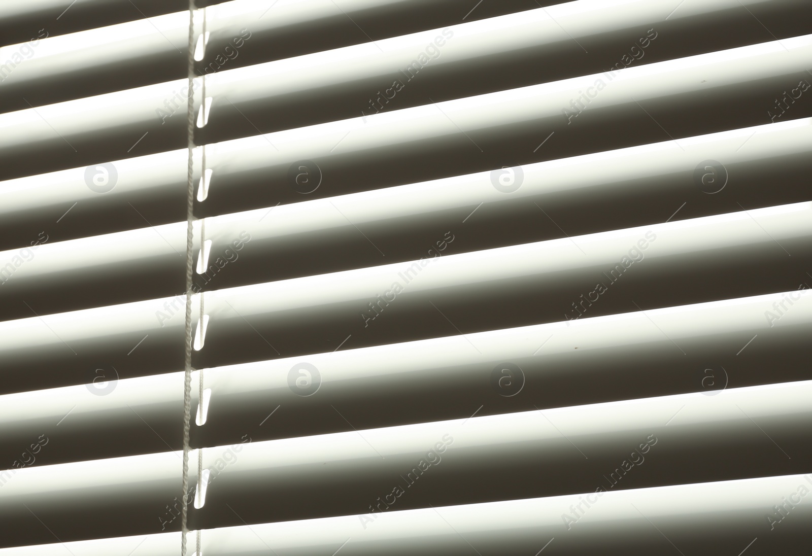 Photo of Closed modern white window blinds, closeup view