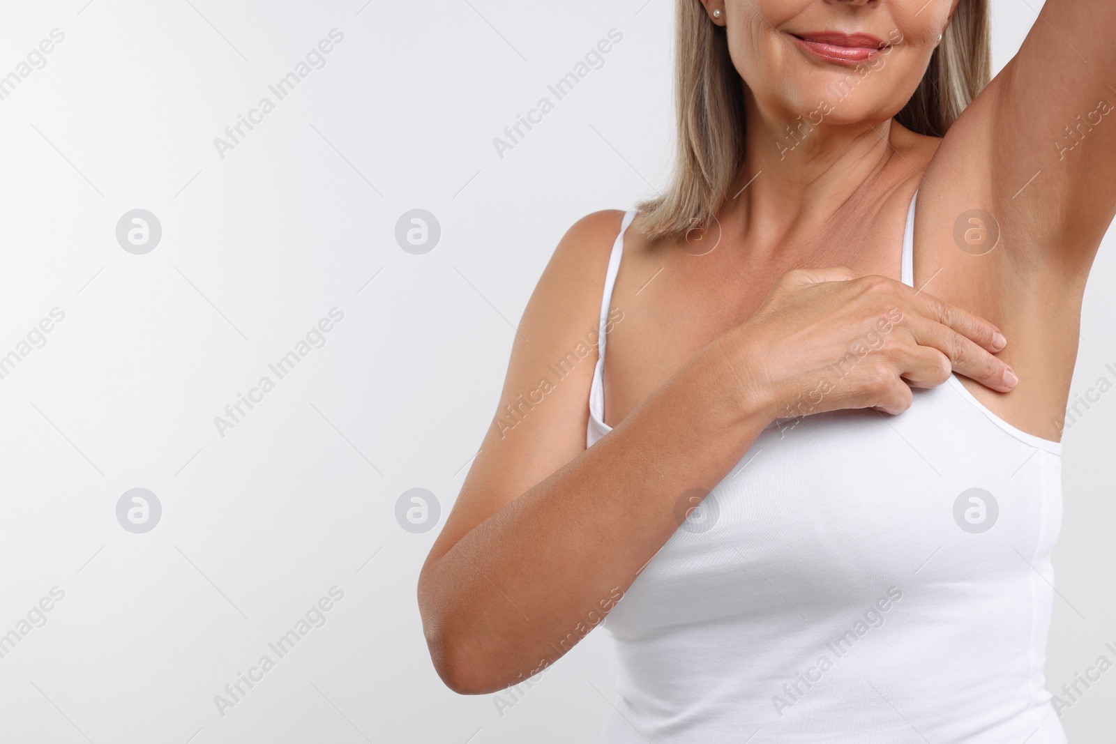 Photo of Woman doing breast self-examination on white background, closeup. Space for text