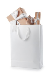 Photo of Paper shopping bag with handles full of gift boxes on white background. Mock up for design