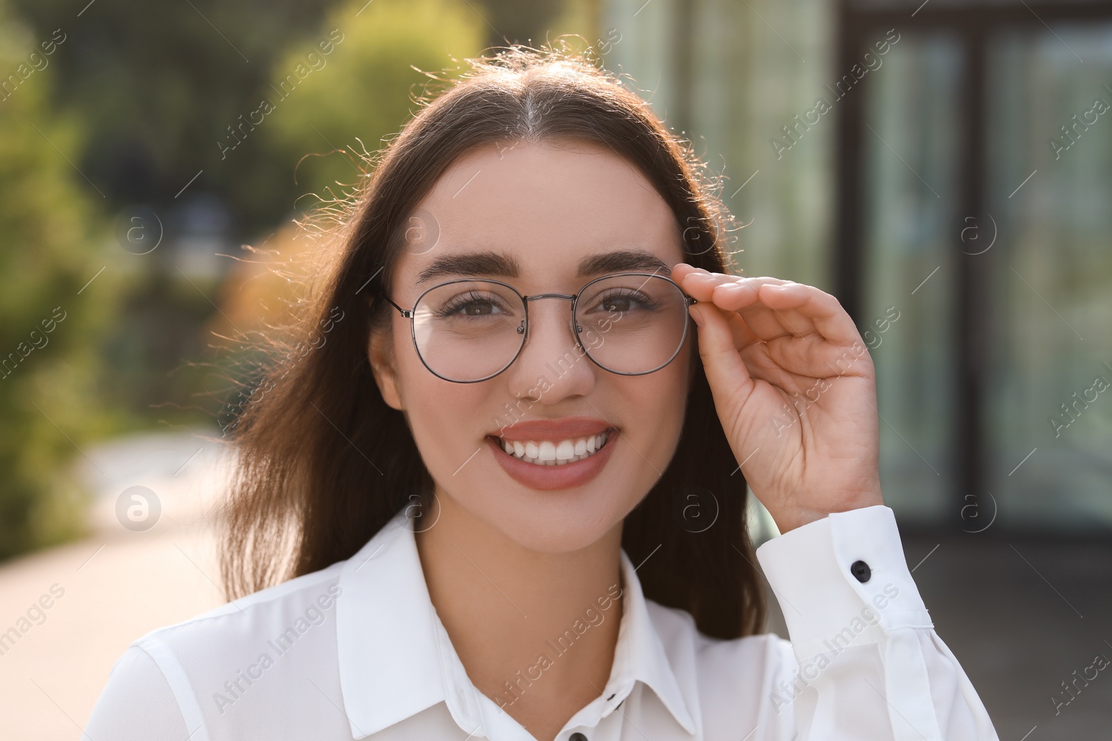 Photo of Portrait of beautiful woman in glasses outdoors. Attractive lady smiling and looking into camera