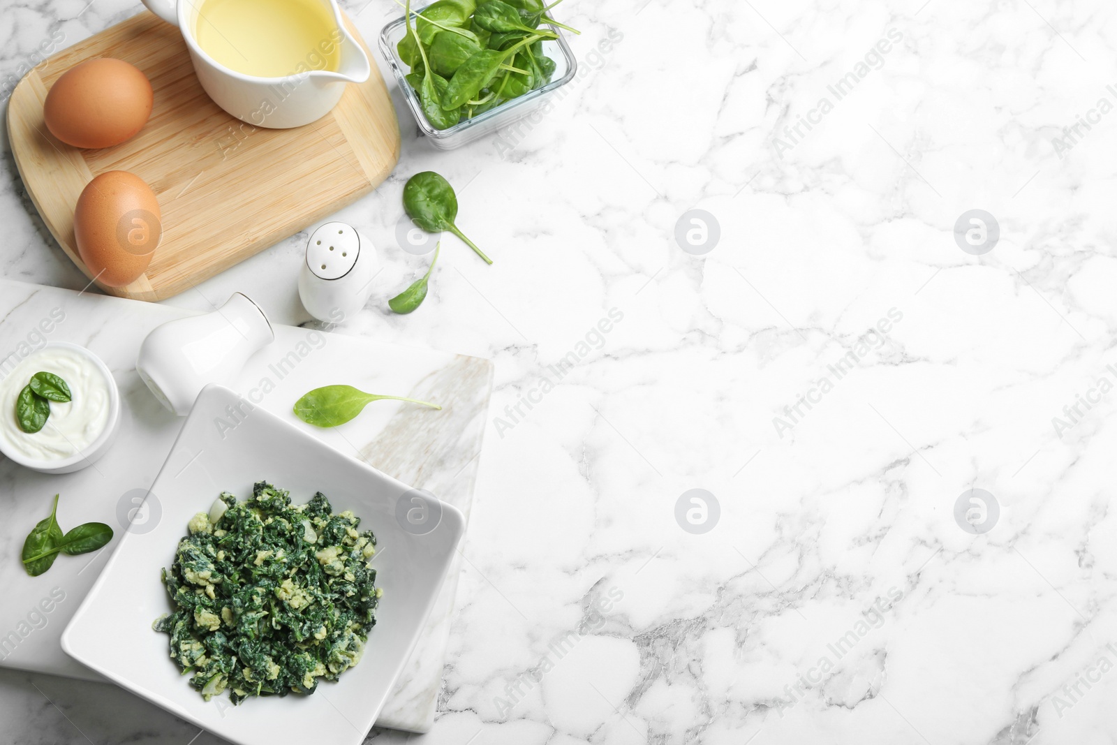 Photo of Flat lay composition with tasty spinach and space for text on white marble table. Healthy food