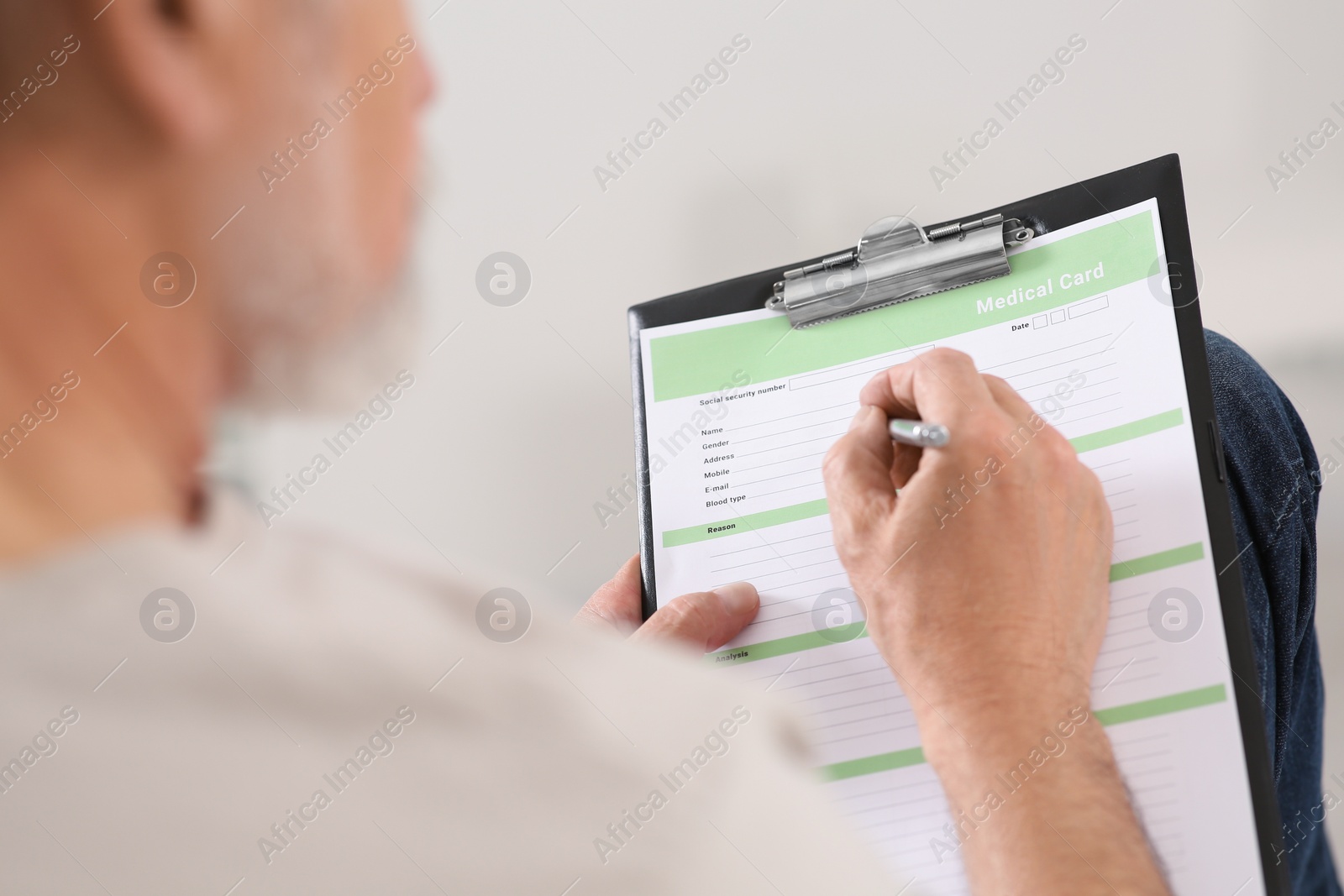 Photo of Patient filling his medical card in clinic, closeup