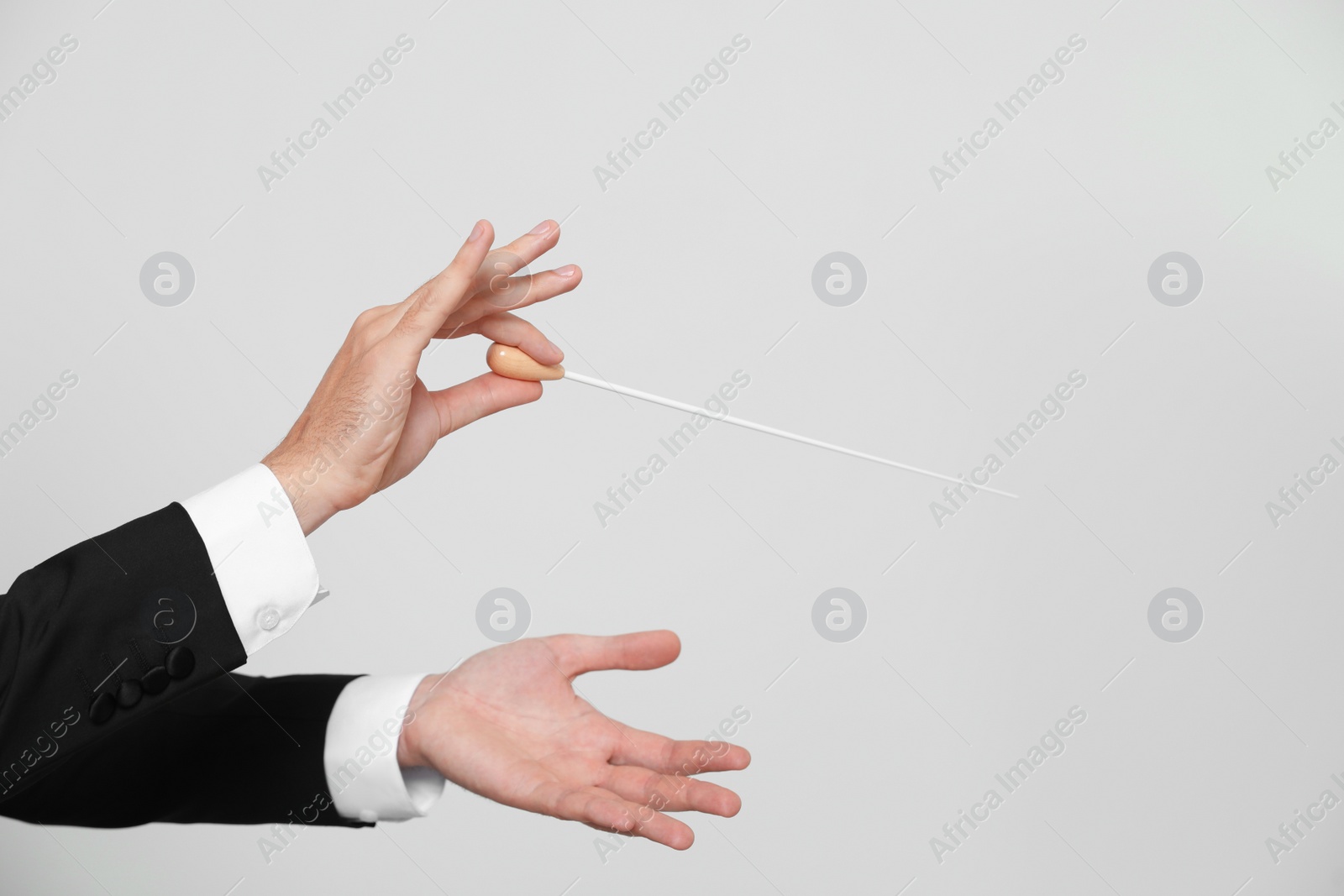 Photo of Professional conductor with baton on light grey background, closeup. Space for text