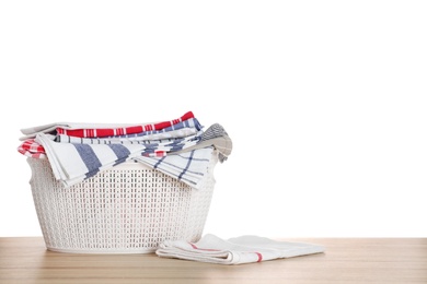 Basket with clean laundry on wooden table, white background