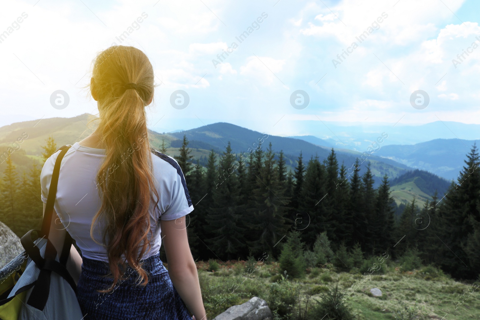 Photo of Woman with backpack in wilderness. Mountain landscape