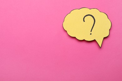Photo of Paper speech bubble with question mark on pink background, top view. Space for text