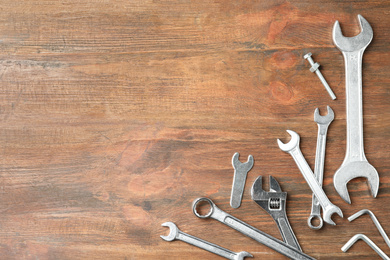 Auto mechanic's tools on wooden background, flat lay. Space for text