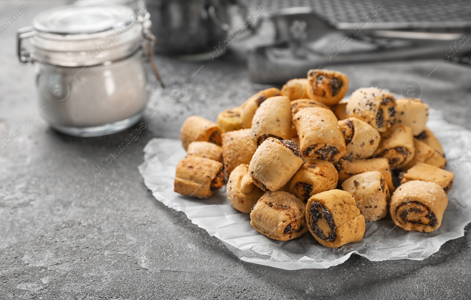 Photo of Tasty sweet cookies with poppy seeds on gray table