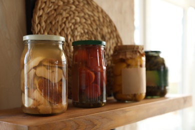 Canned foods on wooden shelf in modern kitchen