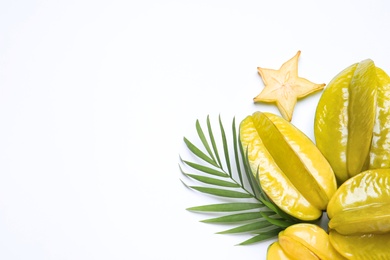 Delicious carambola fruits and leaves on white background, flat lay