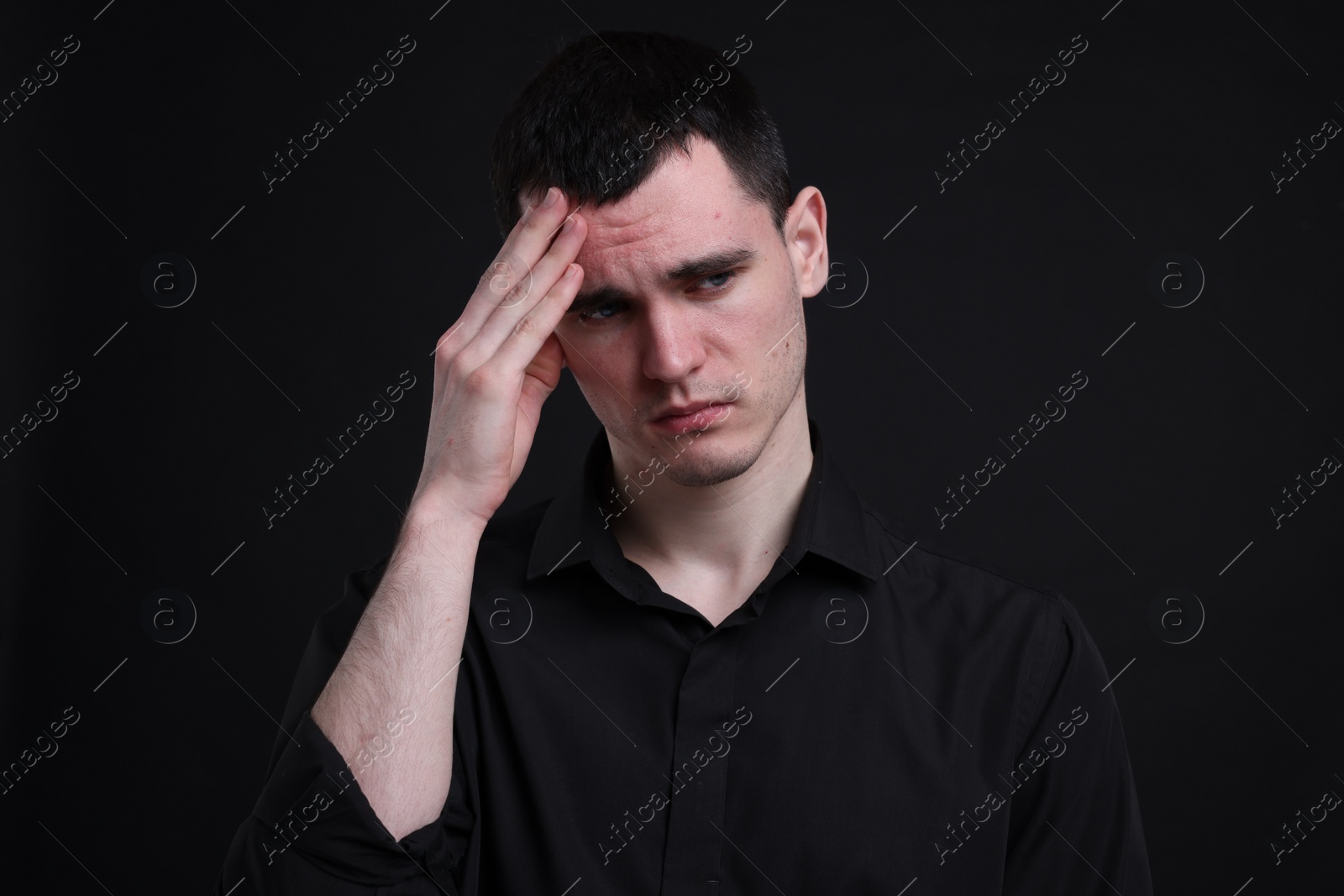 Photo of Portrait of sad man on black background