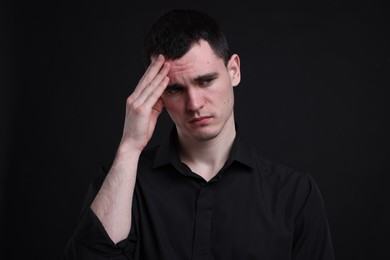 Portrait of sad man on black background