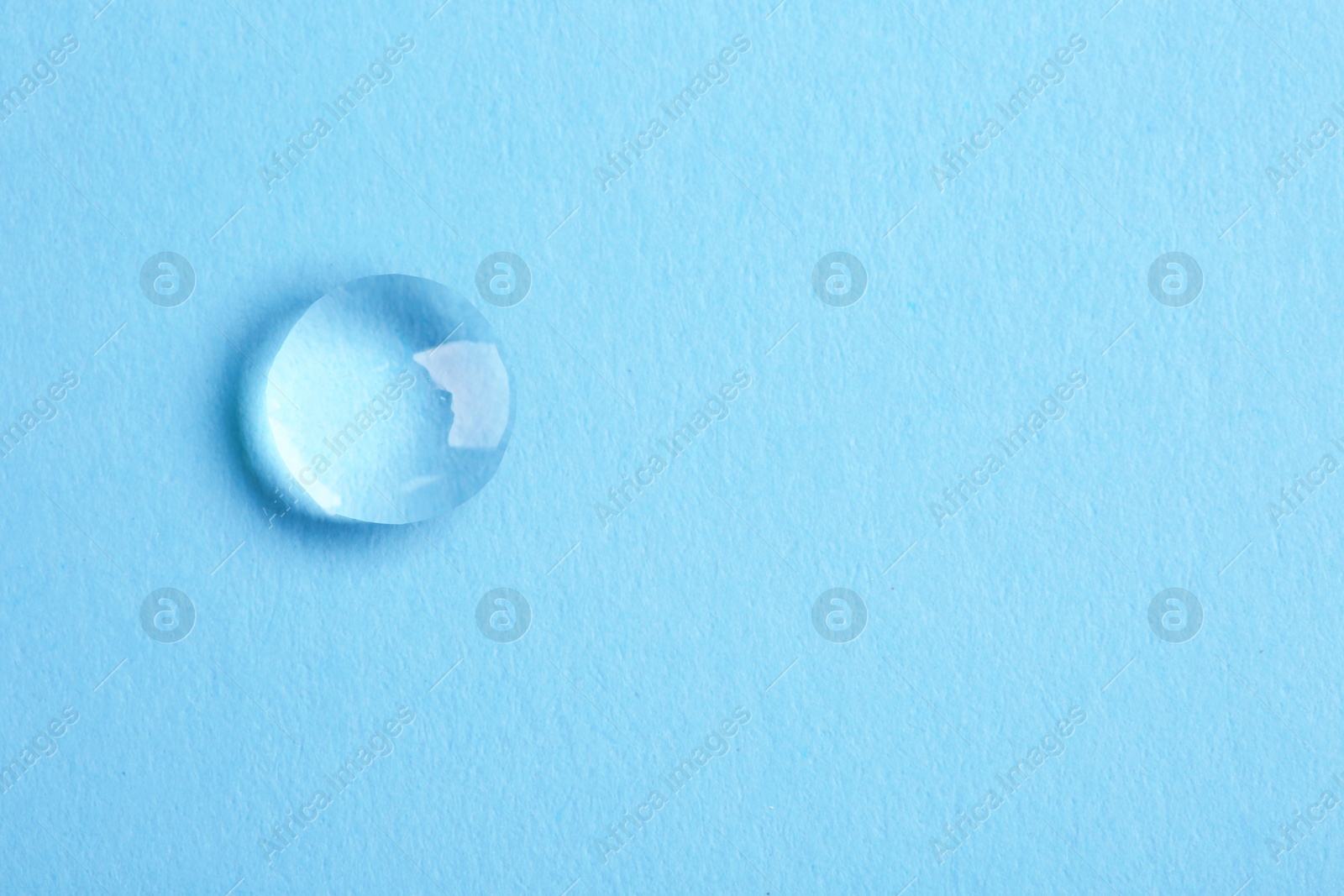 Photo of Water drop on color background, top view. Space for text