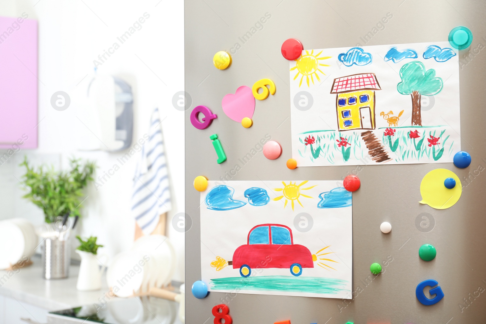 Photo of Child's drawings and magnets on refrigerator door