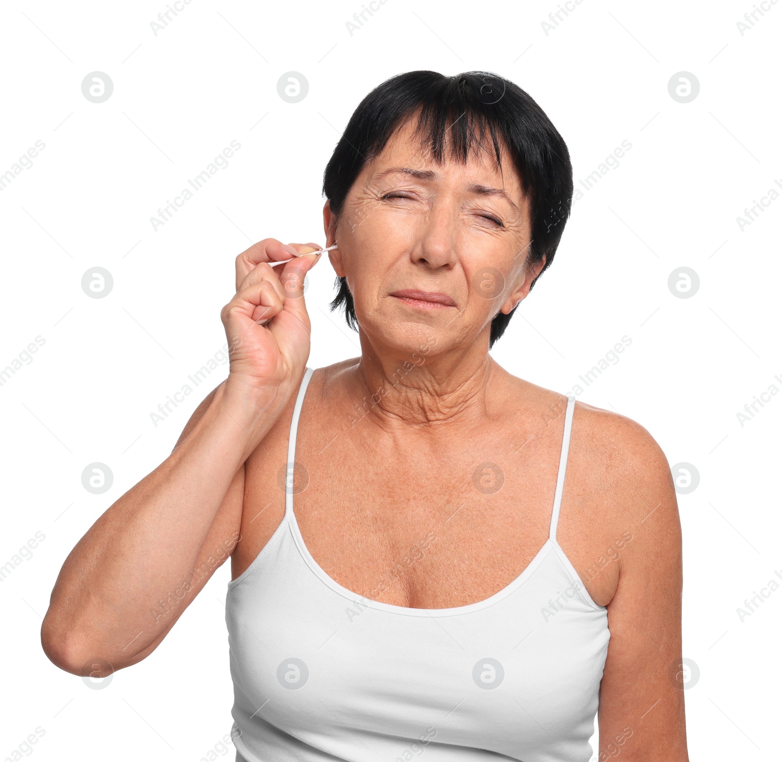 Photo of Senior woman cleaning ear with cotton swab on white background