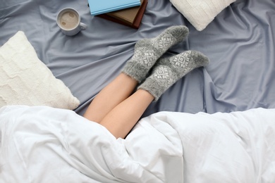 Young woman lying on bed, closeup view of legs. Winter atmosphere