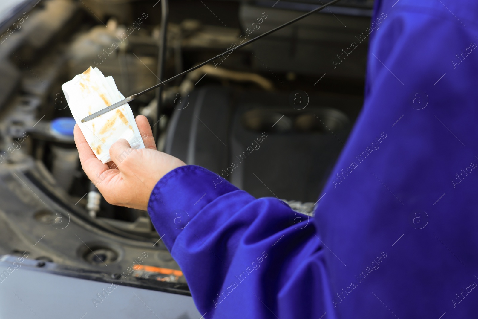 Photo of Man checking motor oil level with dipstick, closeup