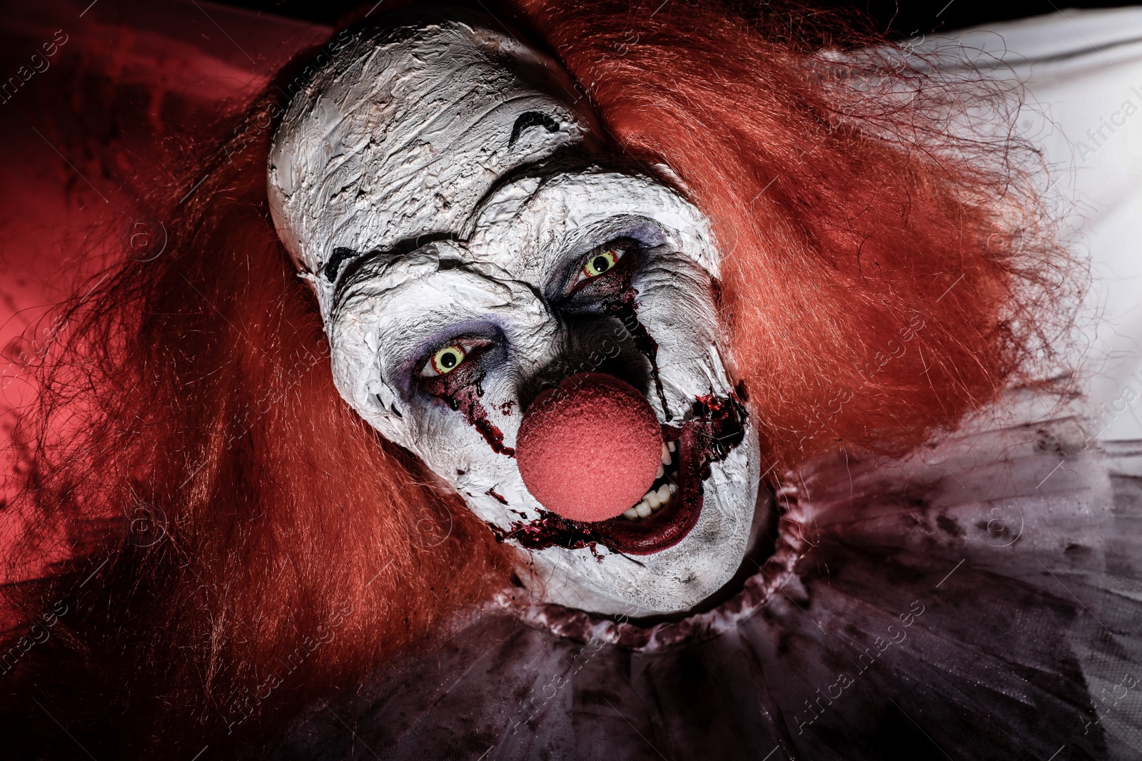 Photo of Portrait of terrifying clown, closeup. Halloween party costume