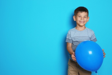 Photo of Cute boy with balloon on color background. Birthday celebration