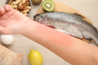 Food allergy. Woman holding hand over products on table, closeup