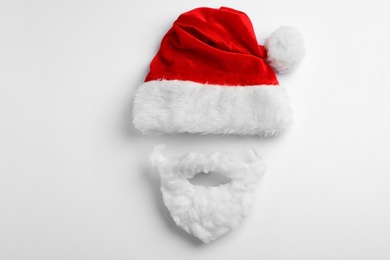 Photo of Santa Claus hat with beard on white background, top view