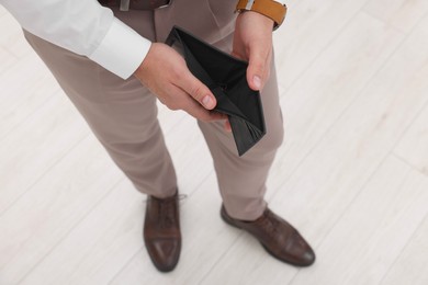 Photo of Man with empty wallet indoors, above view