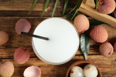 Photo of Fresh lychee juice and fruits on wooden table, flat lay