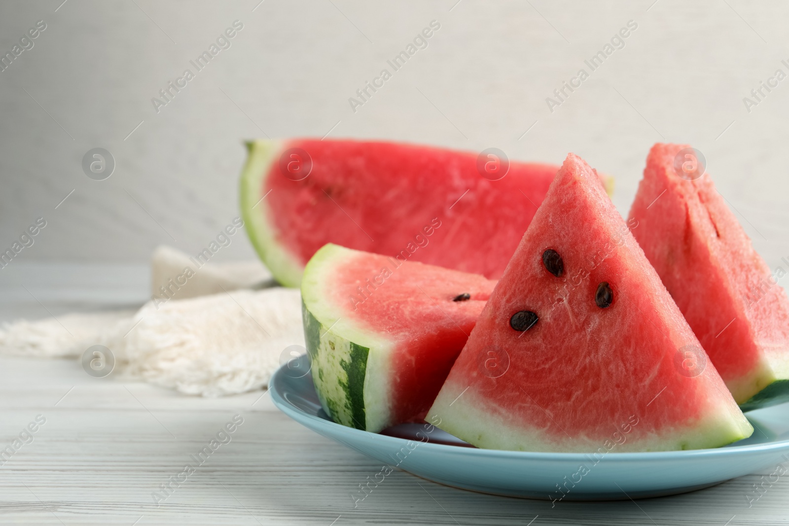 Photo of Delicious fresh watermelon slices on white wooden table