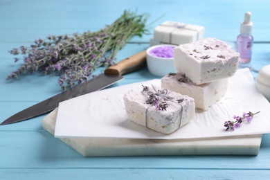 Photo of Hand made soap bars with lavender flowers on light blue wooden table