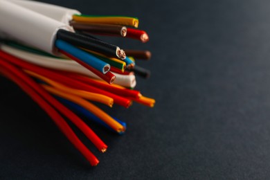 Photo of Many electrical cables on black background, closeup. Space for text