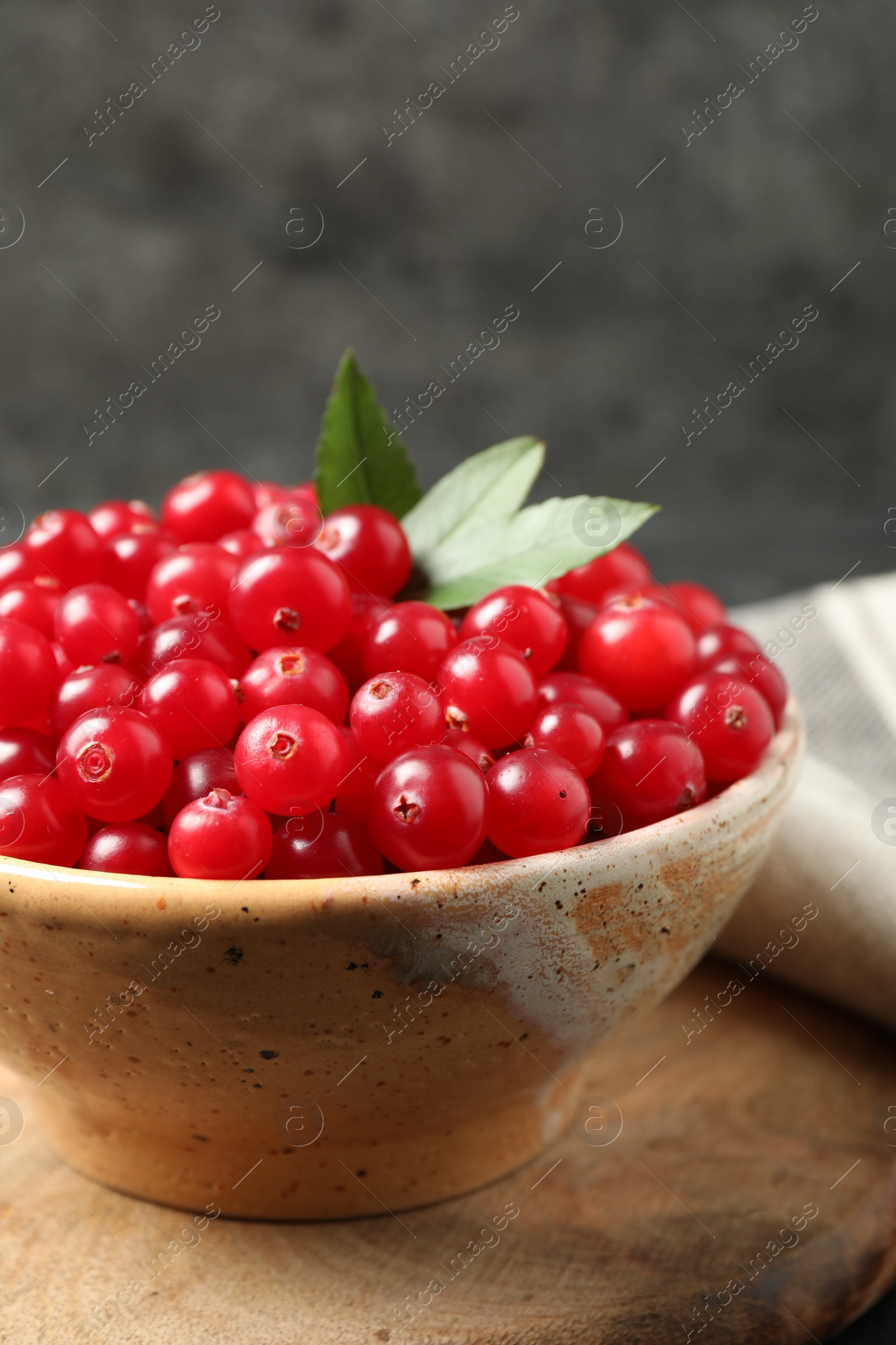 Photo of Tasty ripe cranberries on wooden board, closeup