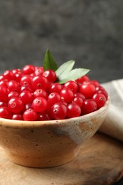 Tasty ripe cranberries on wooden board, closeup