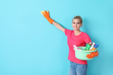 Woman in gloves cleaning color wall with rag