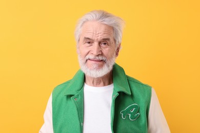 Photo of Portrait of stylish grandpa on yellow background