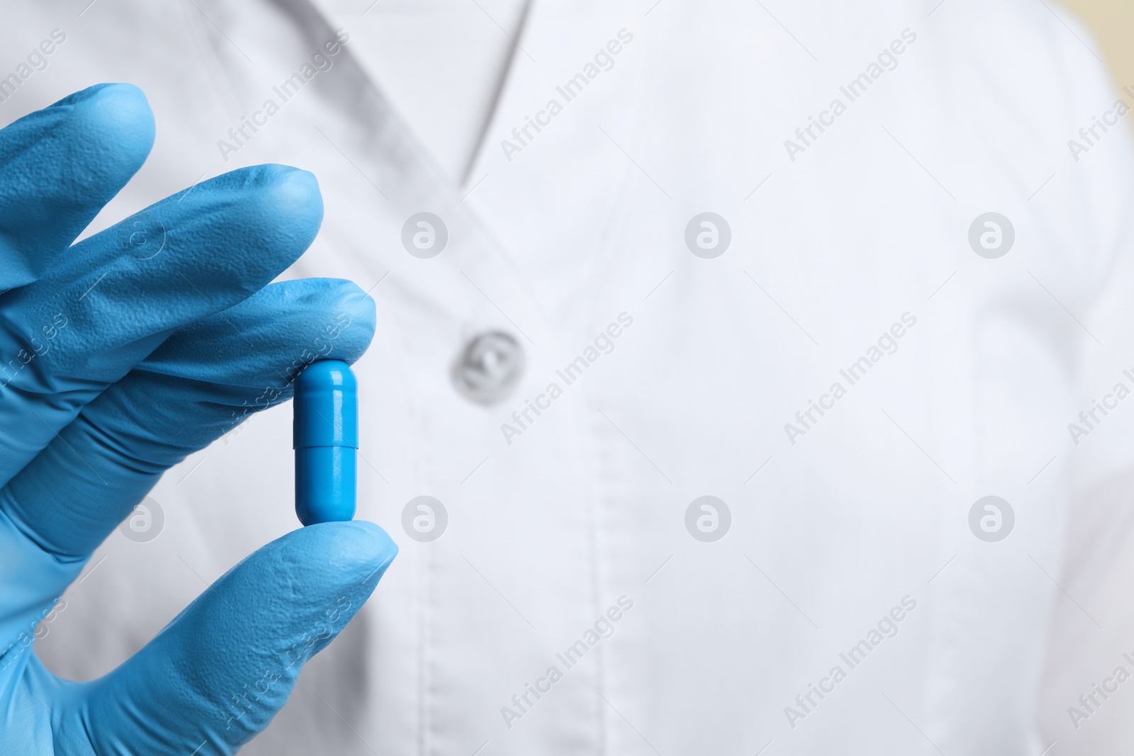 Photo of Doctor holding pill, closeup. Space for text