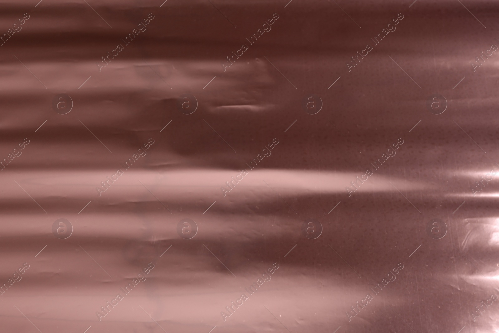 Photo of Plain rose gold surface as background, closeup