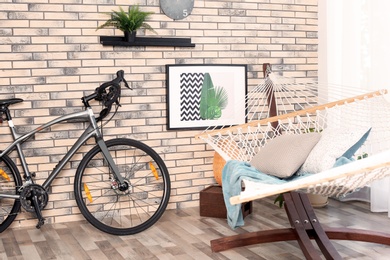 Photo of Modern bicycle and hammock in stylish room interior