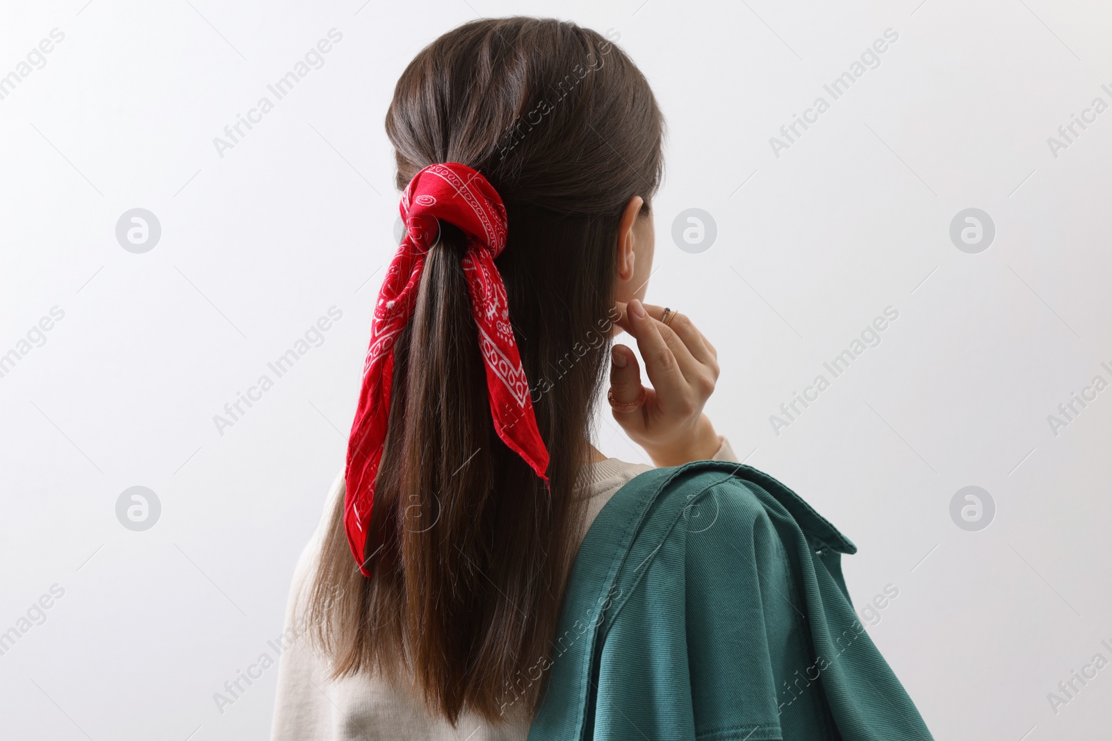 Photo of Young woman with stylish red bandana on light background, back view