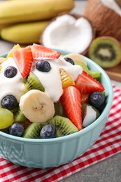Delicious fruit salad with yogurt on table