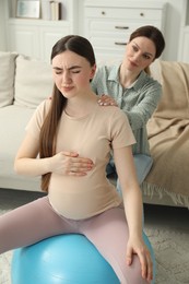 Photo of Doula massaging pregnant woman at home. Preparation for child birth