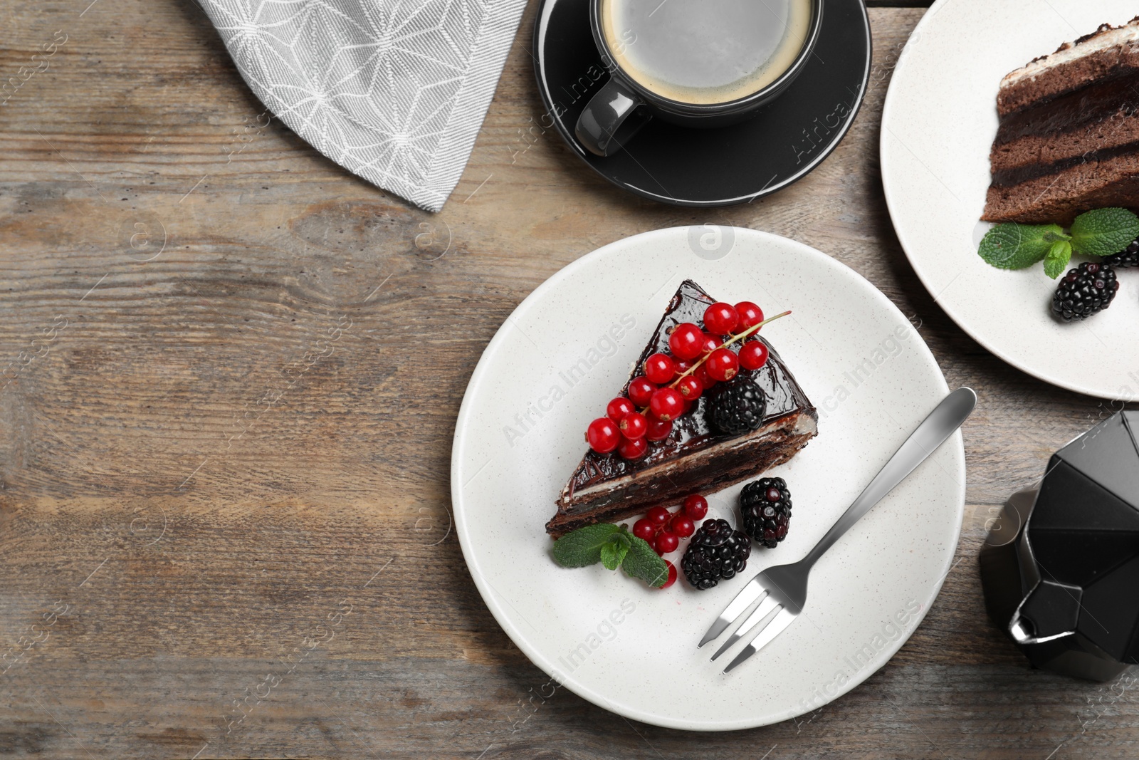 Photo of Tasty chocolate cake with berries on wooden table, flat lay