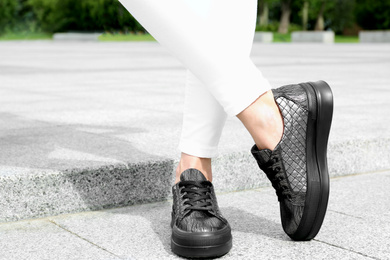 Woman wearing comfortable stylish shoes outdoors, closeup