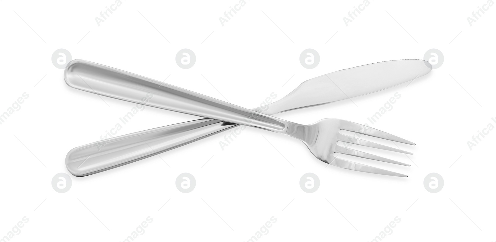 Photo of Knife and fork isolated on white, top view. Stylish shiny cutlery set