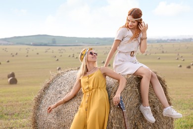 Beautiful happy hippie women with guitar in field