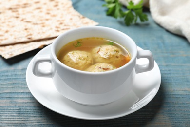 Photo of Bowl of Jewish matzoh balls soup on color wooden table